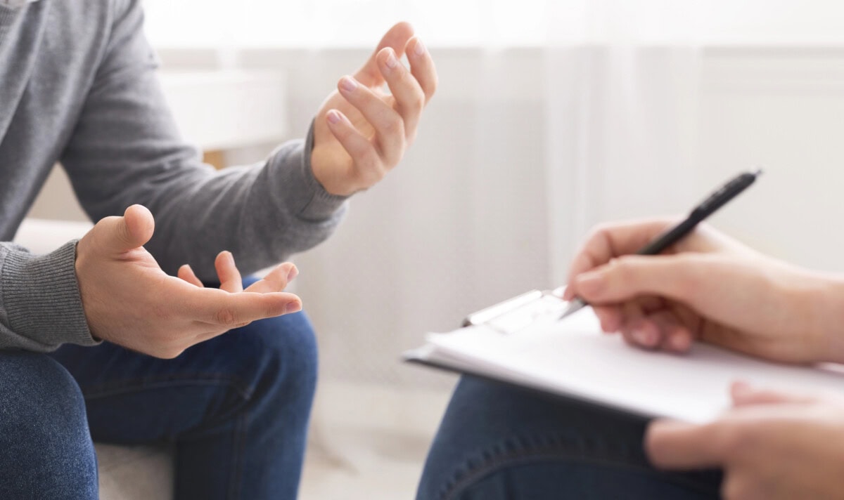 Psychotherapist writing notes, assessing patients health and giving diagnosis